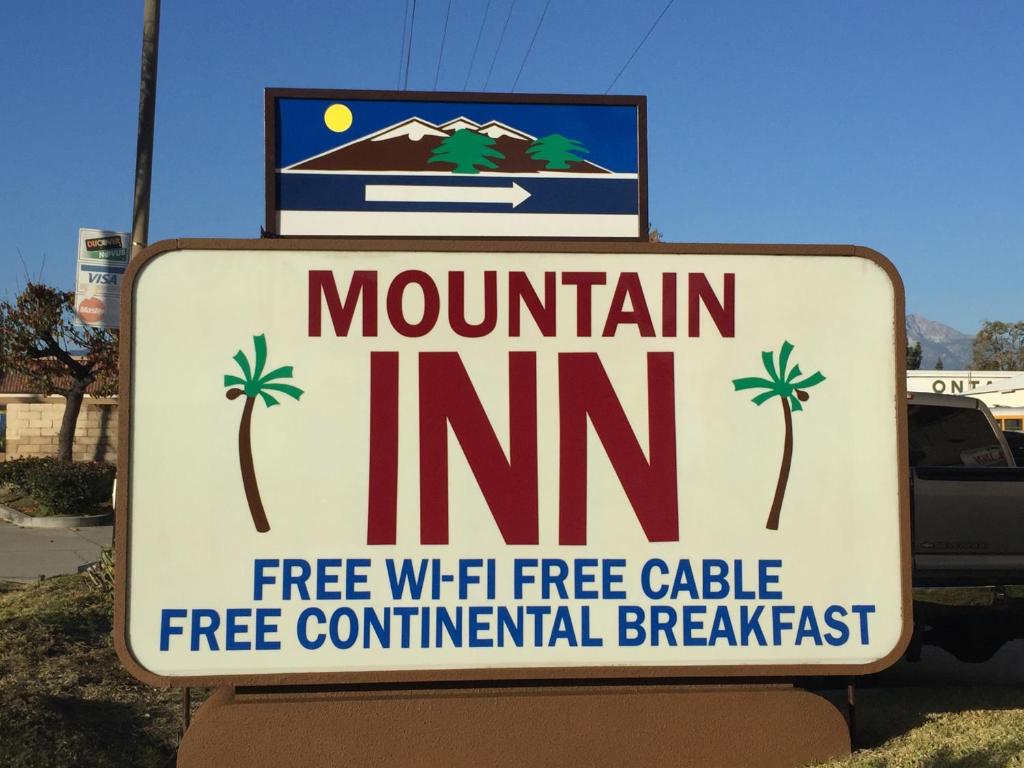 a sign for a mountain inn with palm trees on it at Mountain Inn in Ontario