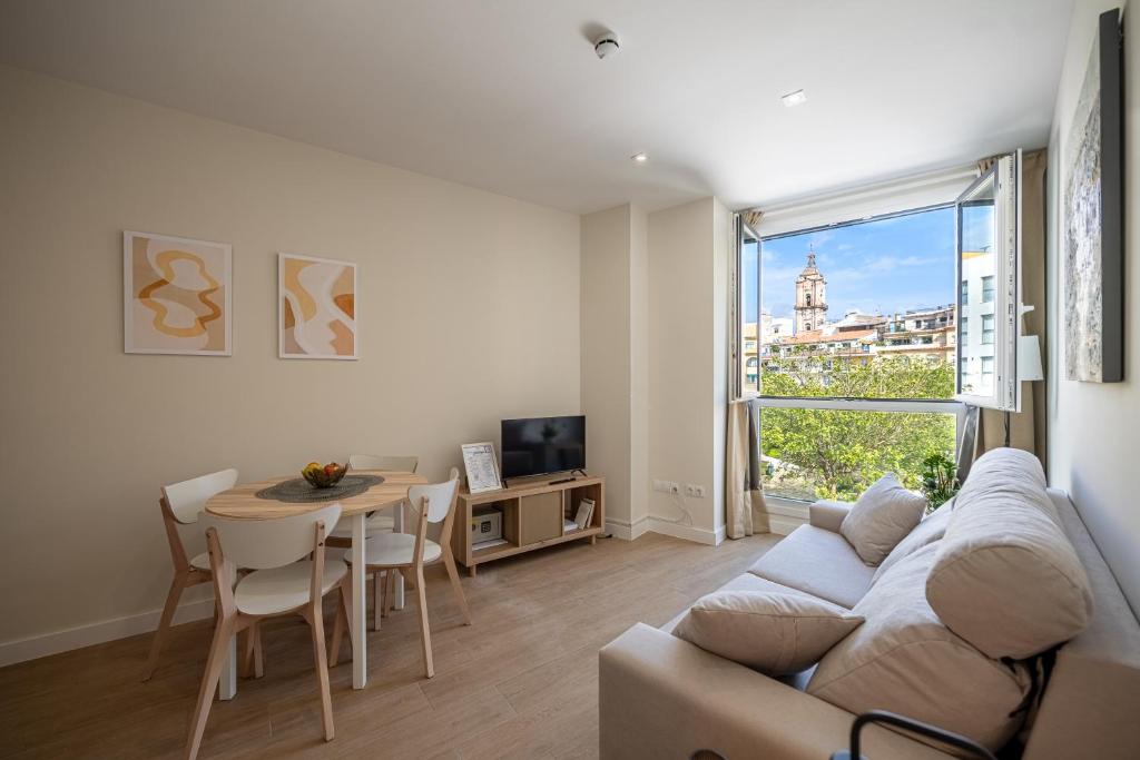 Hotel AT Villafiel Atarazanas-Plaza, a living room with a couch and a table at AT Villafiel Atarazanas-Plaza in Málaga