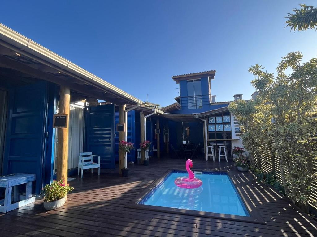 a pink swan in a swimming pool on a house at Capim Limão Containers do Rosa in Praia do Rosa