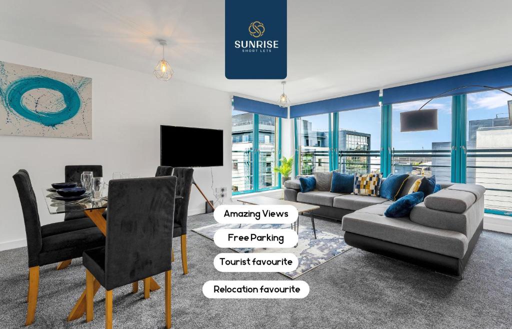un soggiorno con un divano e un tavolo di THE PENTHOUSE- INVOICE and REDUCED PRICE only via SUNRISE SHORT LETS DUNDEE, Spacious, Stunning Views, Foosball Table, 3 Large Rooms, Central Location, River Front, 1 Min From Tay Bridge, V&A, Train Station, City Centre, Lift Access, Free Parking & WiFi a Dundee