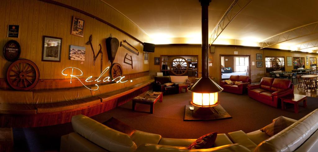 a living room with couches and a sign that says relax at Snowy Mountains Resort and Function Centre in Adaminaby