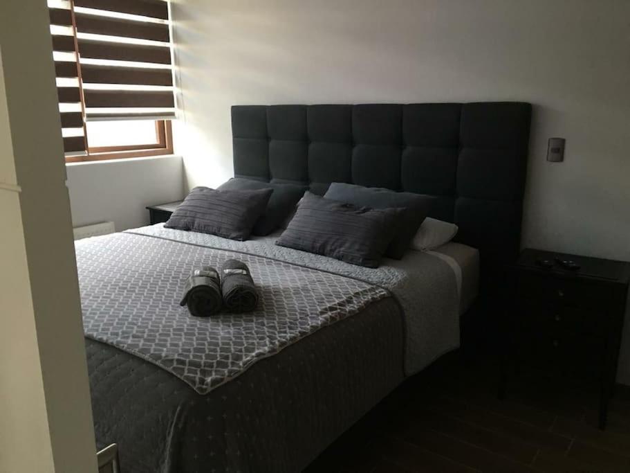 ein Schlafzimmer mit einem großen Bett mit Schuhen drauf in der Unterkunft Concepción pleno centro in Concepción