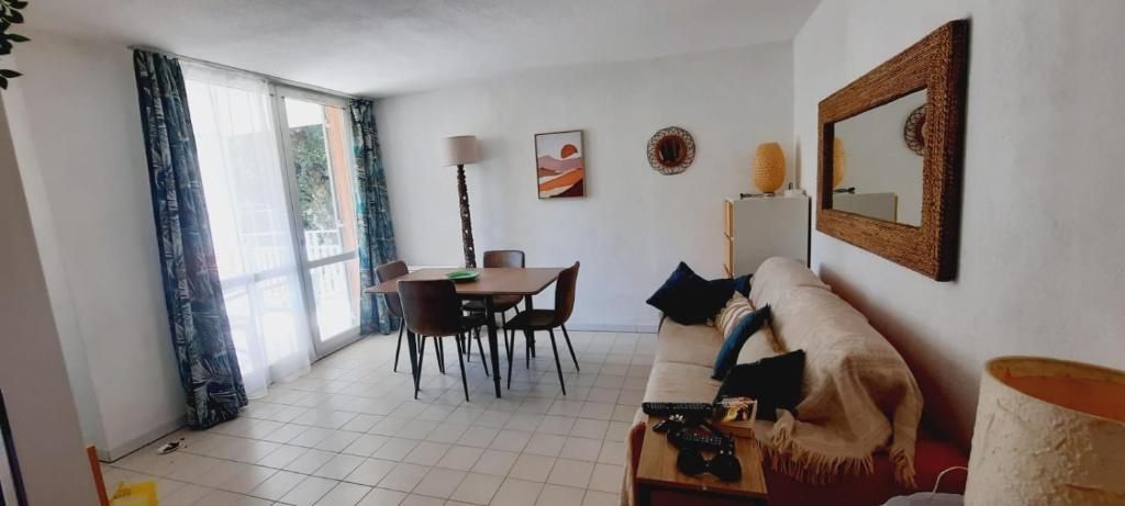 un salon avec un canapé et une table dans l'établissement CAVALIERE LE LAVANDOU Au Chêne Liège, au Lavandou