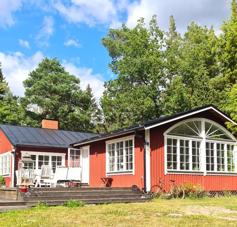 Casa roja con ventanas blancas y porche en Awesome Home In Skälvik With 2 Bedrooms And Wifi, en Skälvik