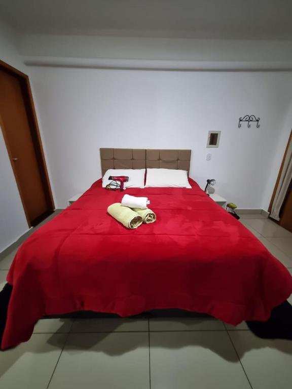 a large red bed with two towels on it at Apto Girassol in Monte Verde