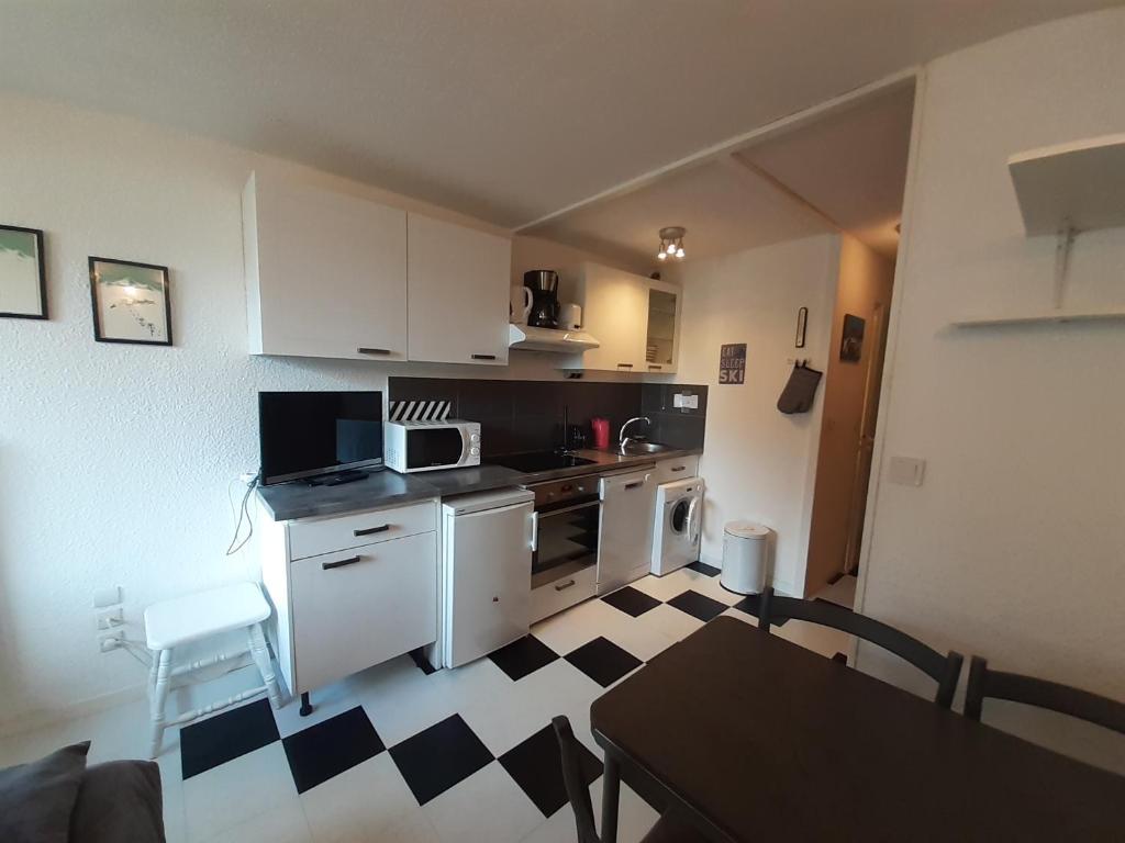 - une petite cuisine avec un sol en damier noir et blanc dans l'établissement Studio cosy proche télécabine à Valfréjus - FR-1-561-130, à Modane