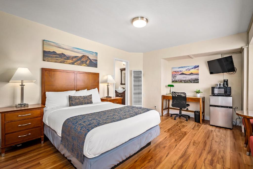 a hotel room with a large bed and a desk at Sunbeam Motel in San Luis Obispo