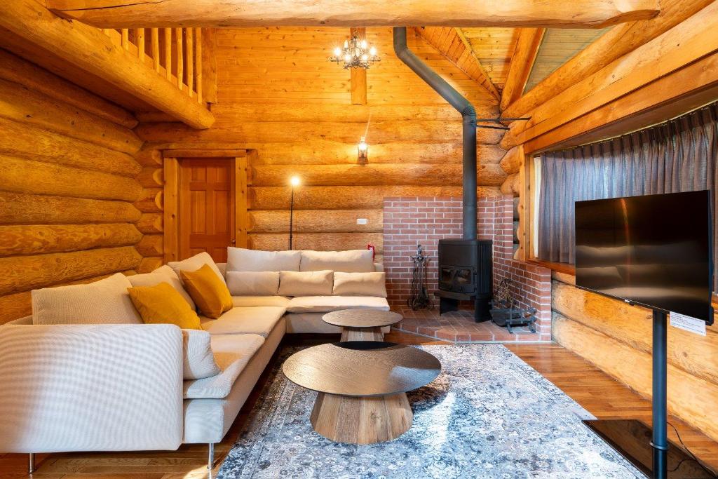 a living room with a couch and a fireplace at S-villa Karuizawa Muguet in Hoshina