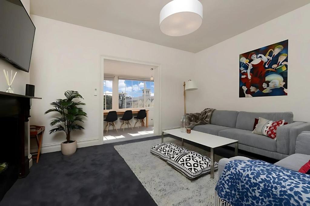 a living room with a couch and a table at The Lollyshop Apartment in Battery Point in Hobart