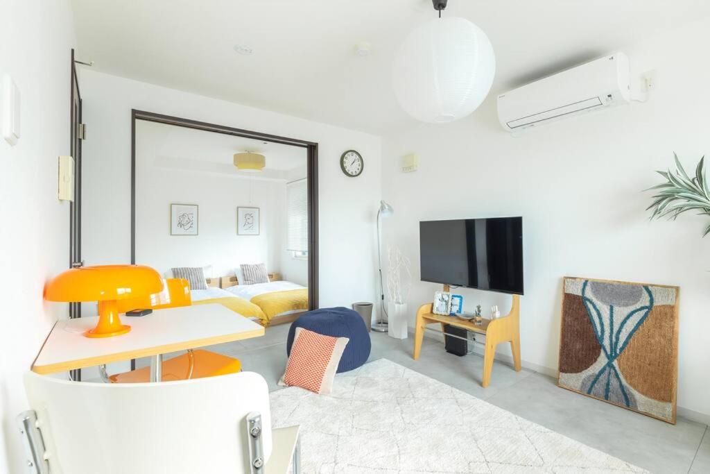 a living room with a bed and a television at Cozy Stay Sapporo East 405 in Sapporo