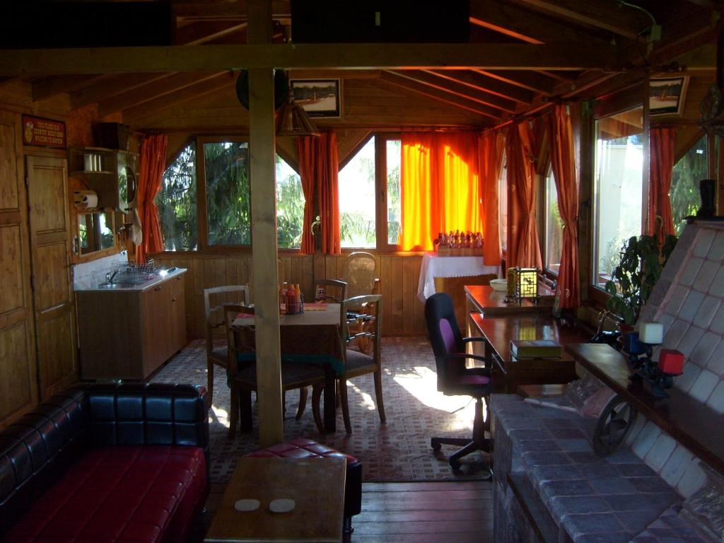 a dining room with a table and chairs and windows at Transylvania Cowboy Cottage in Cluj-Napoca