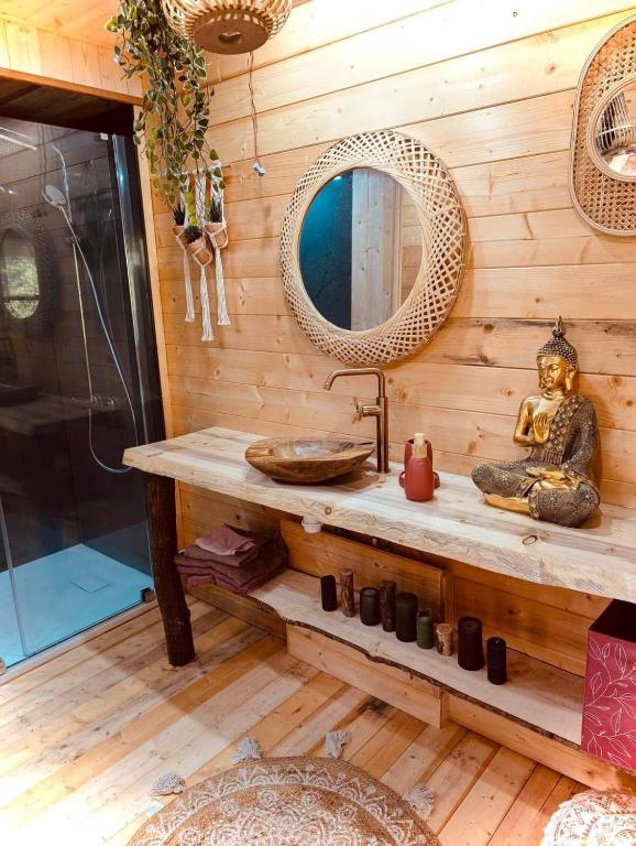 un bagno con lavandino e specchio di Cabane Coco bohème a Azereix