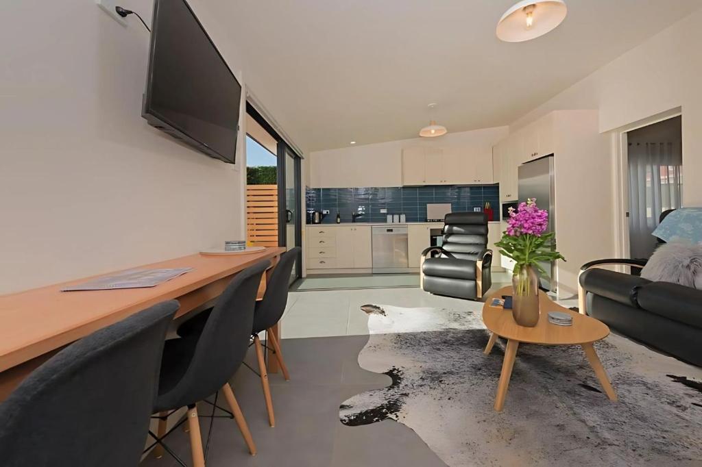 a living room with a desk with chairs and a couch at The Little Lollyshop Apartment in Battery Point in Hobart