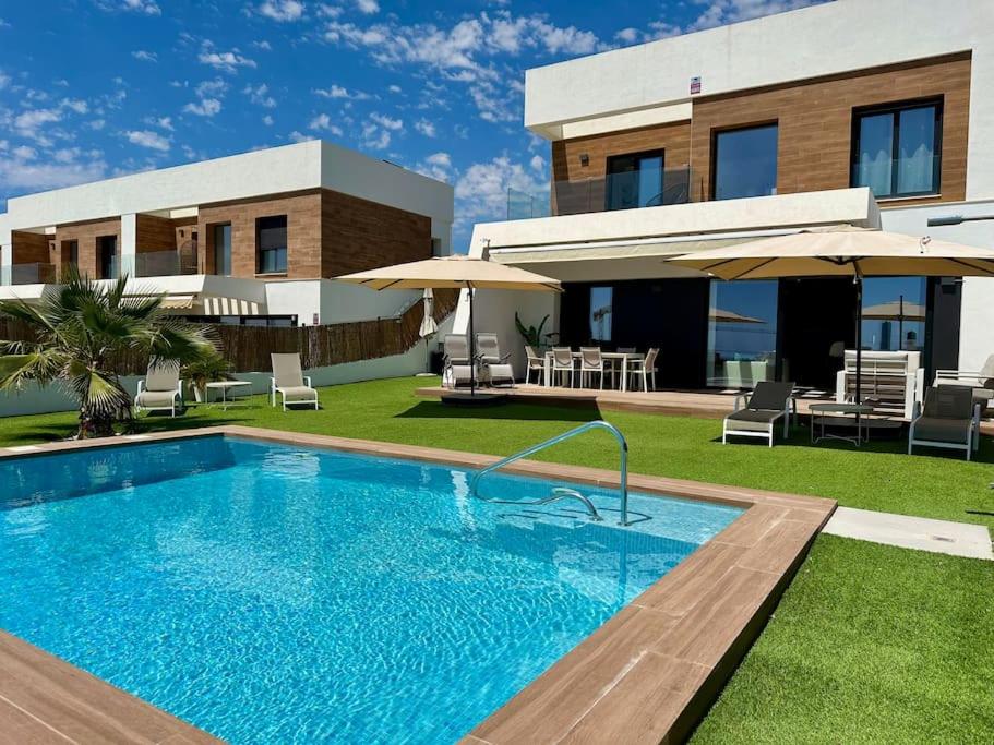 a swimming pool in front of a house at Villa Finestrat Benidorm Golf y Playa in Cala de Finestrat