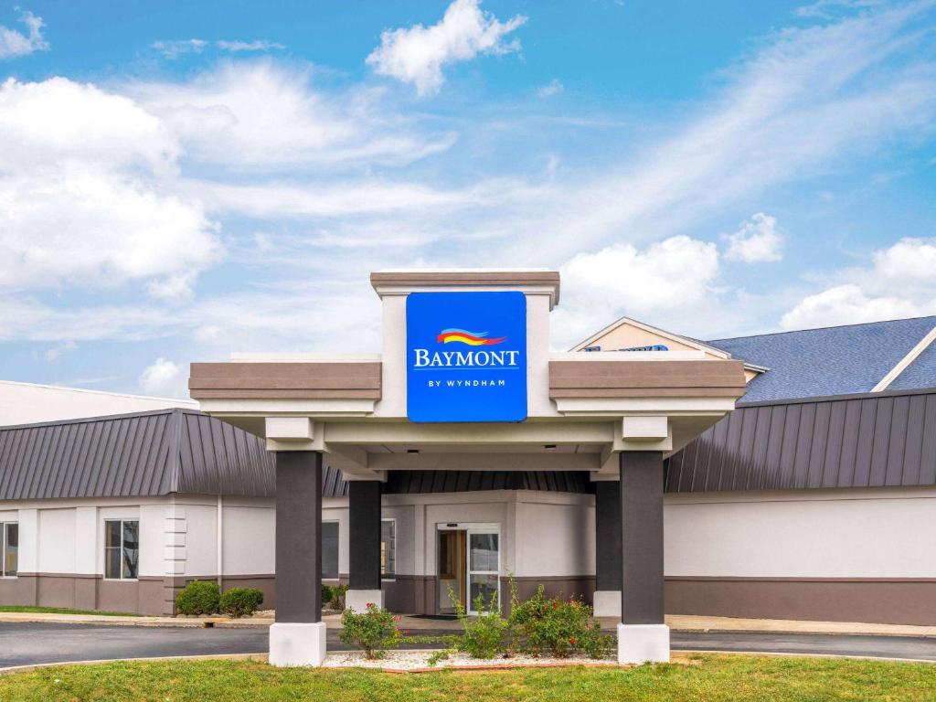 a building with a blue bank sign on it at Baymont by Wyndham Indianapolis East in Indianapolis