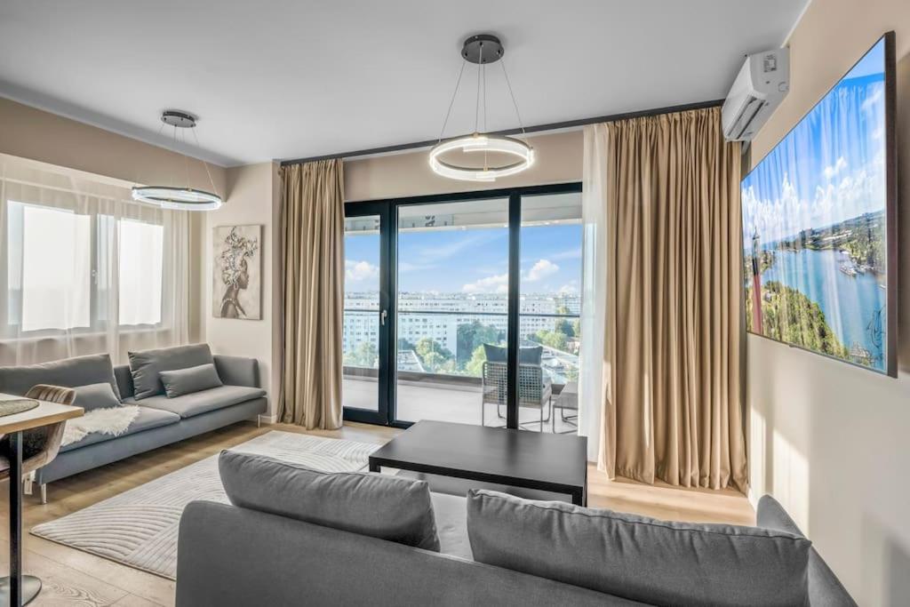 a living room with a couch and a large window at Majestic Skyline in Balta Albă