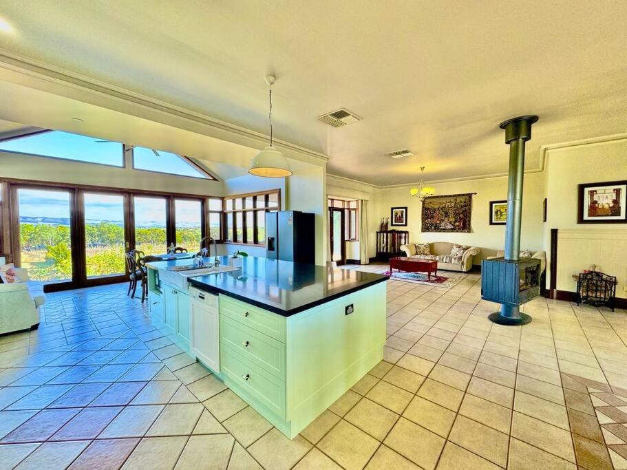 a large kitchen with a counter top and a living room at Condor Estate Spacious with Vineyard & Fireplace in Maslin Beach