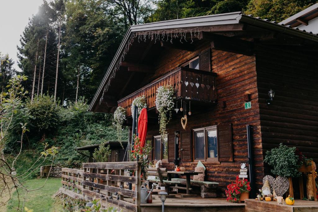 una baita di tronchi con un tavolo di fronte ad essa di Knusperhäuschen a Sattendorf