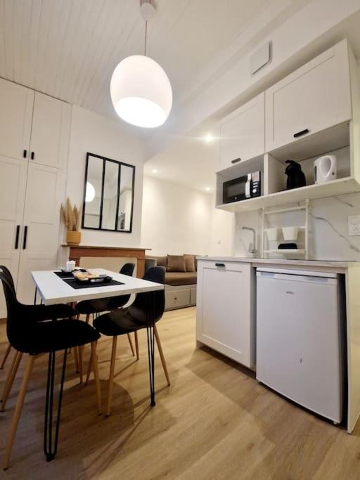 une cuisine et un salon avec une table et des chaises dans l'établissement La petite parenthèse au centre ville, à Chalon-sur-Saône