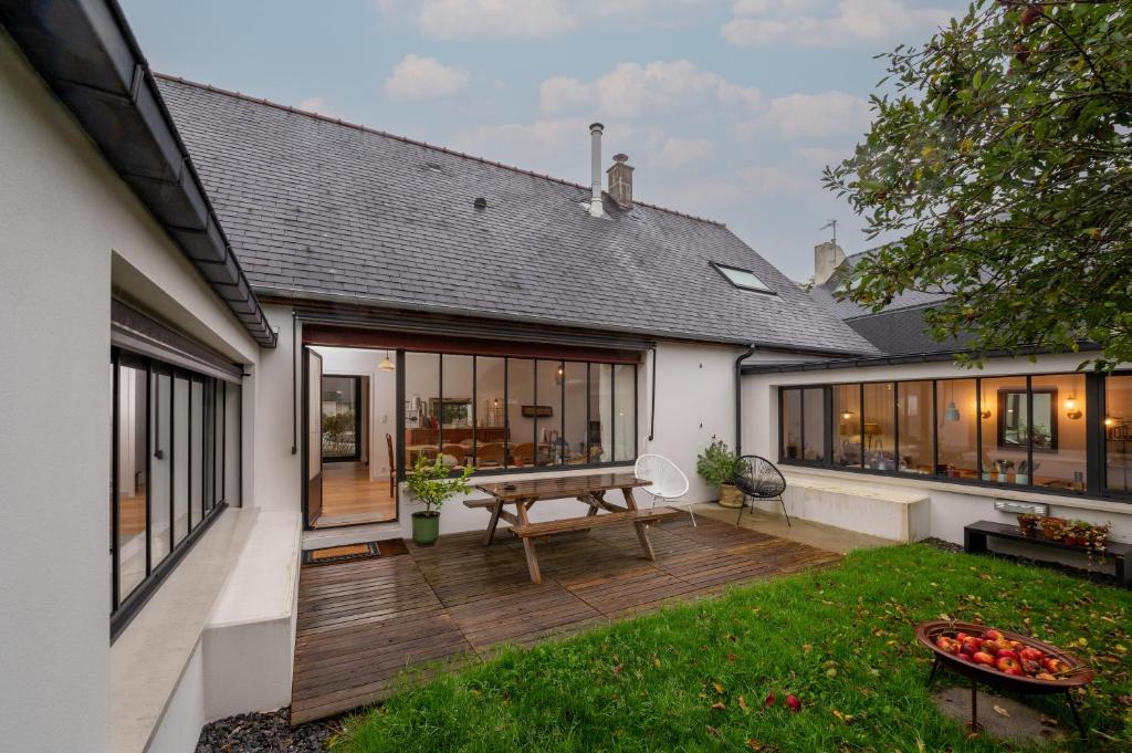 une arrière-cour avec une terrasse en bois et un banc dans l'établissement Maison Chaleureuse - La Cayola, à Larmor-Plage