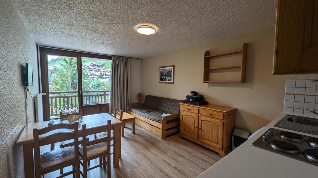 - une cuisine avec un canapé et une table dans une chambre dans l'établissement Résidence Meijotel - Studio résidence Meijotel MAE-9291, à Vénosc