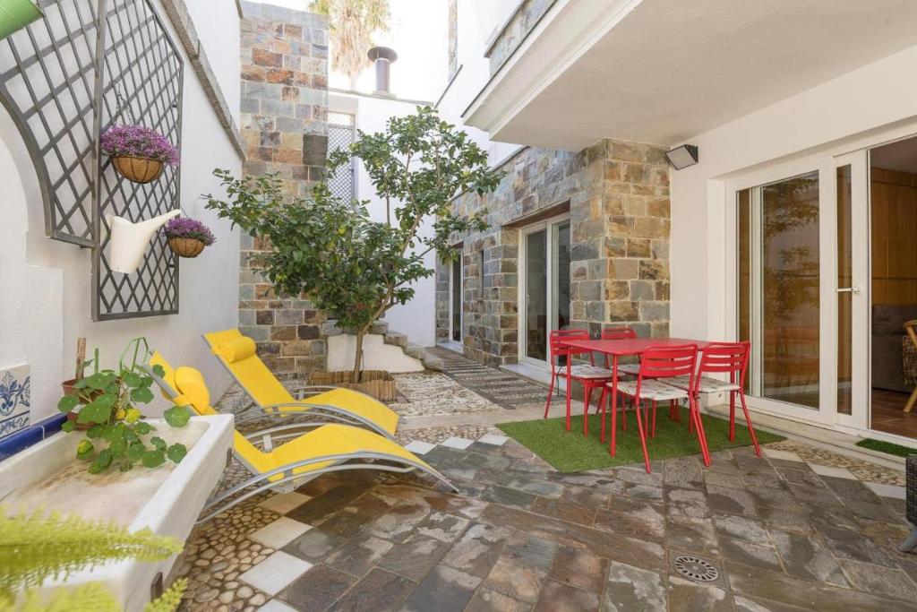 a patio with a red table and yellow chairs at Flamenco Soul in Chiclana de la Frontera