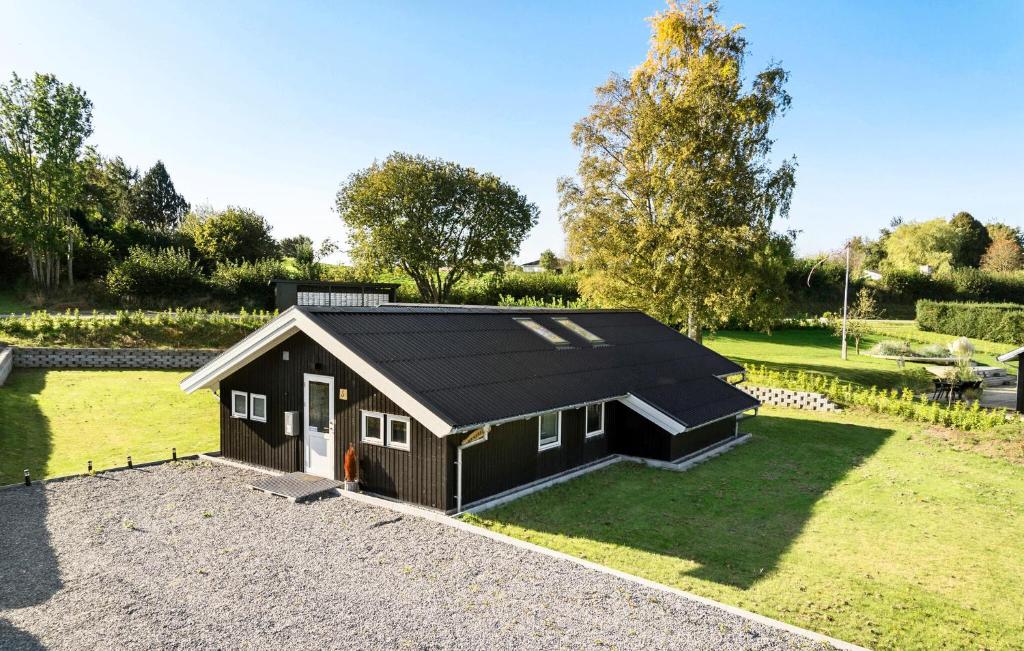 un piccolo capanno con un tetto nero su un prato di 5 Bedroom Cozy Home In Hejls a Hejls