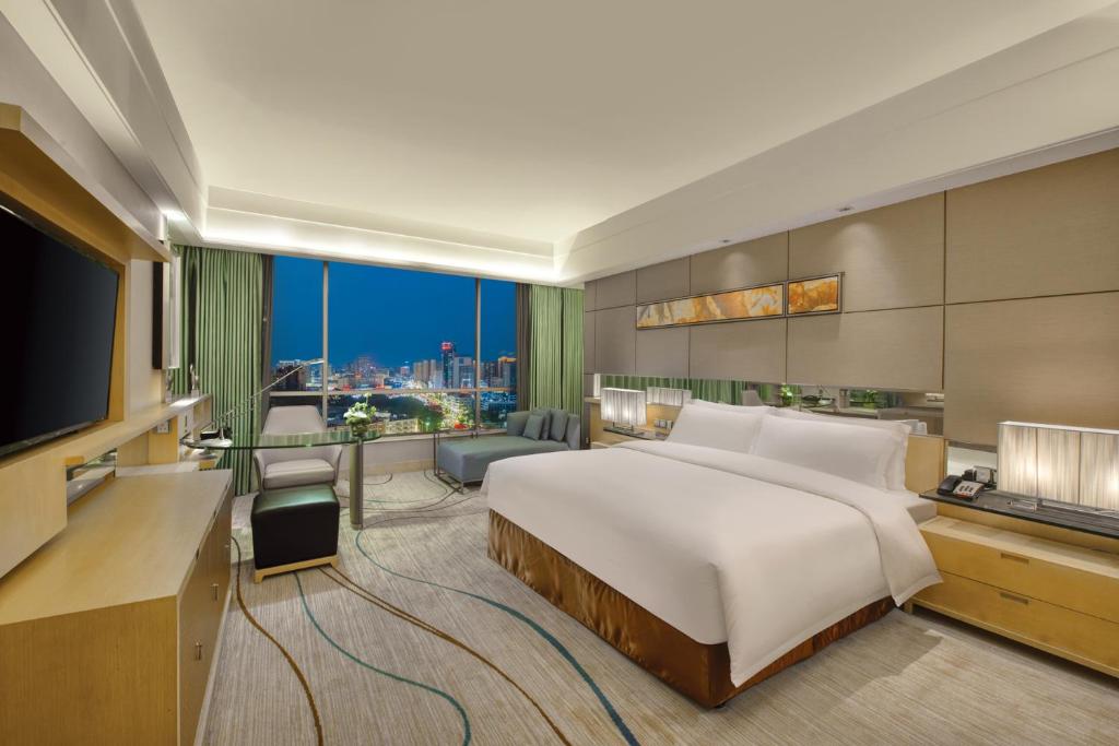 Postel nebo postele na pokoji v ubytování Dongguan Royal Garden Hotel