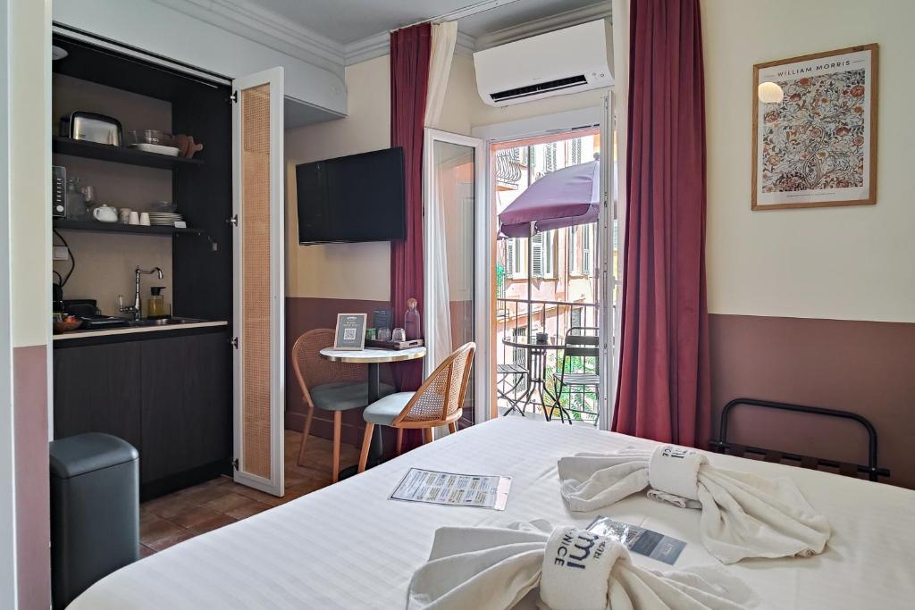 a room with a bed and a kitchen and a table at Aparthotel AMMI Vieux Nice in Nice