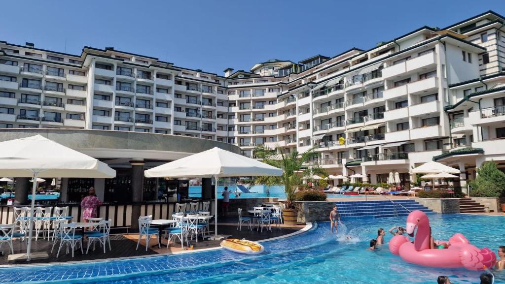 una piscina dell'hotel con fenicotteri rosa e persone di Emerald Beach Resort welnes & spa a Ravda