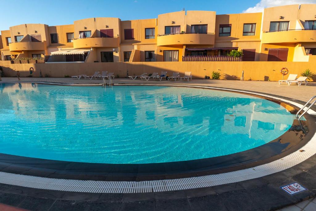 een groot zwembad voor een gebouw bij Casa Carola - Bahia Sol in Caleta De Fuste