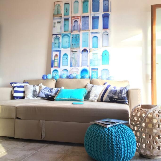 a couch in a living room with a painting on the wall at Argentario nice dreams in Porto Santo Stefano