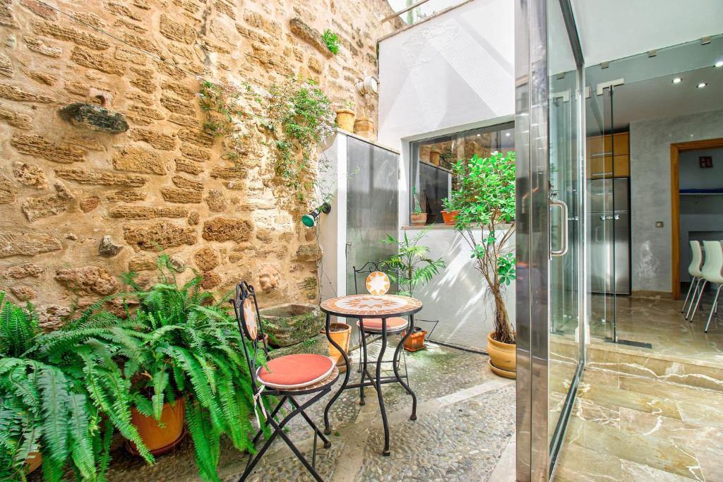 a patio with a table and chairs next to a brick wall at Ca Se Predine by Rentallorca in Alcudia