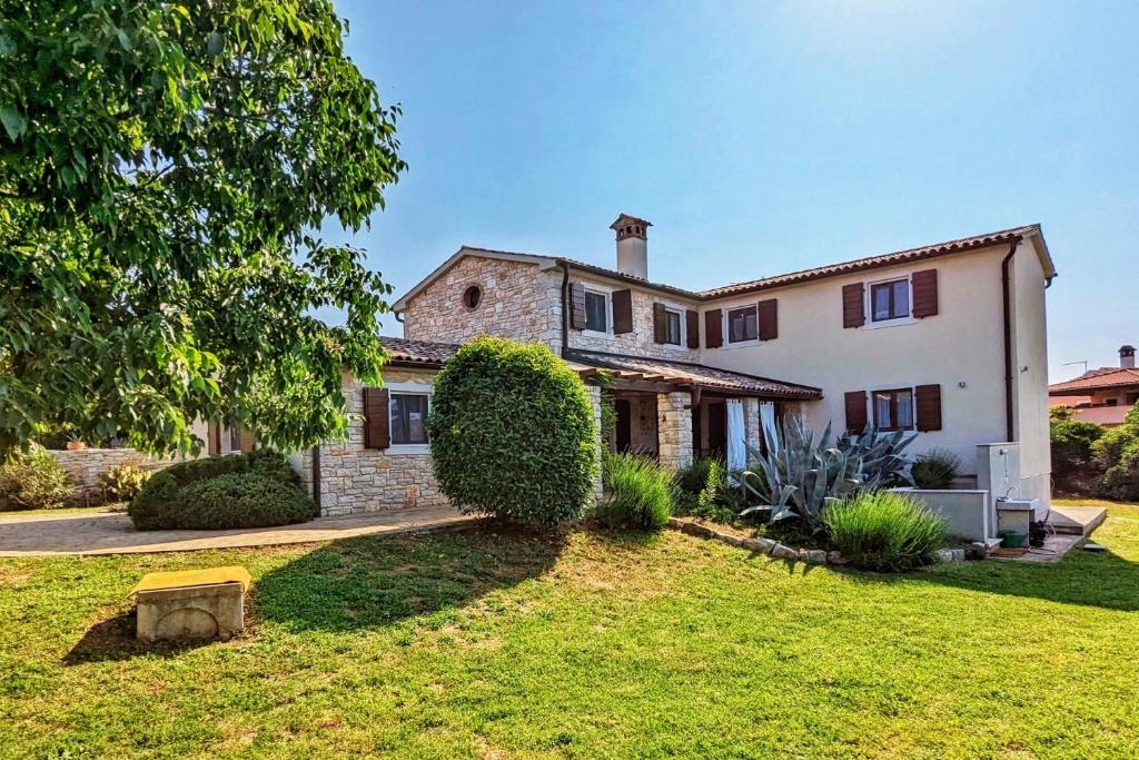a large stone house with a grass yard at Casa Le Finide in Bale
