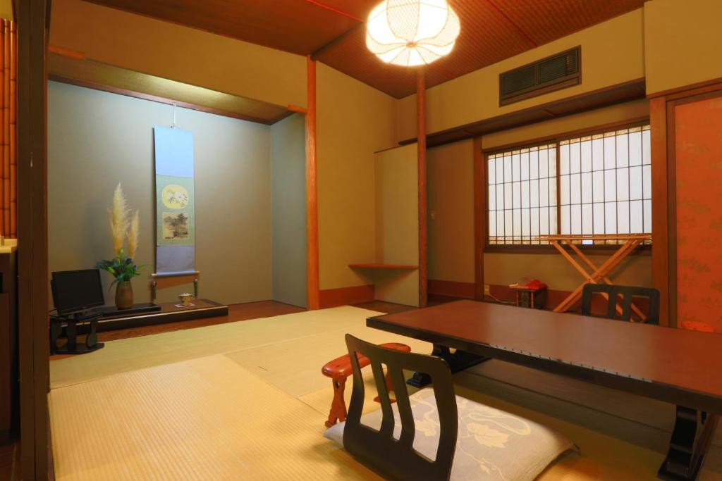 a dining room with a wooden table and chairs at 割烹旅館小川荘 in Ōmiya