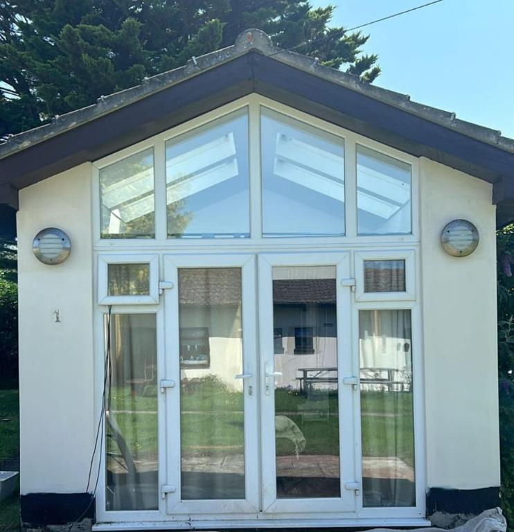 a conservatory with glass doors on a house at #1 Stoneleigh Cottage in Seaton