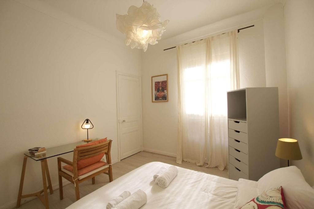 une chambre avec un lit, un bureau et une chaise dans l'établissement Authentique et spacieux 3 pieces, à Beausoleil