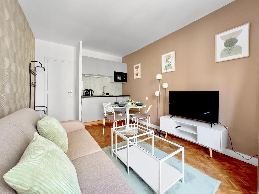 un salon avec un canapé et une table dans l'établissement Appartement Cosy 2P- Trocadero La Muette, à Paris