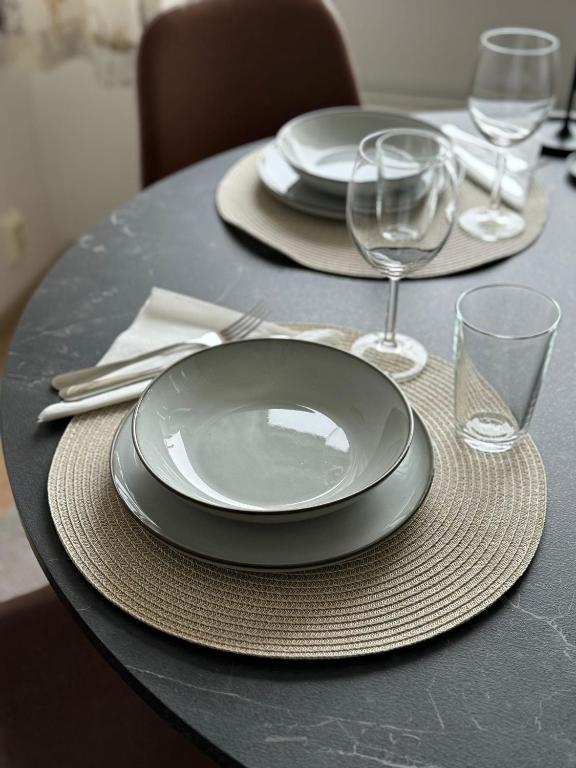a table with plates and wine glasses on it at Arctic Jaakko Suite in Rovaniemi