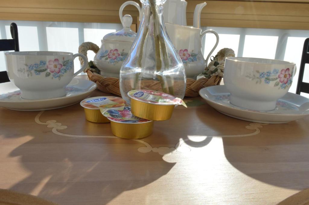 a table with a vase and tea cups on it at B&B Al Golfo in Salerno