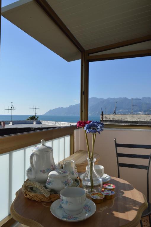 a table with a tea set on top of a balcony at B&B Al Golfo in Salerno