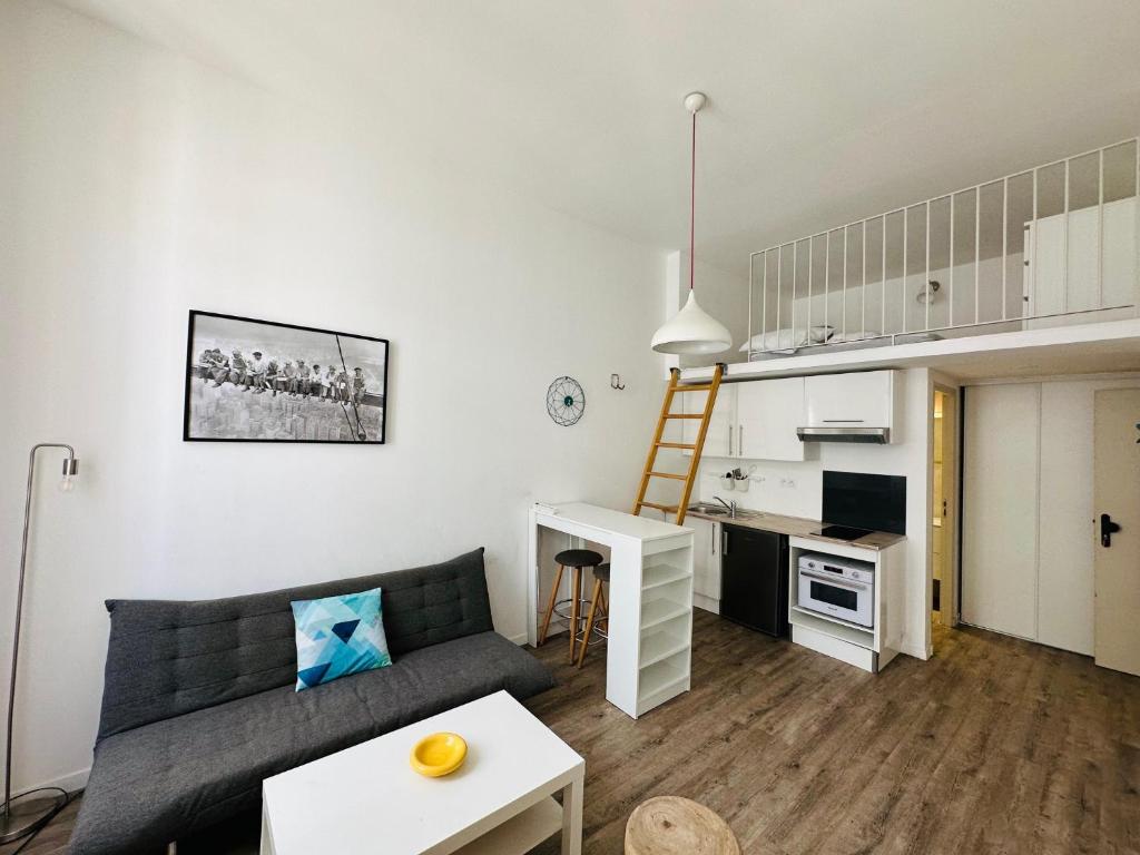 un salon avec un canapé et une petite cuisine dans l'établissement Résidence 41 Léon Noel, à Cannes