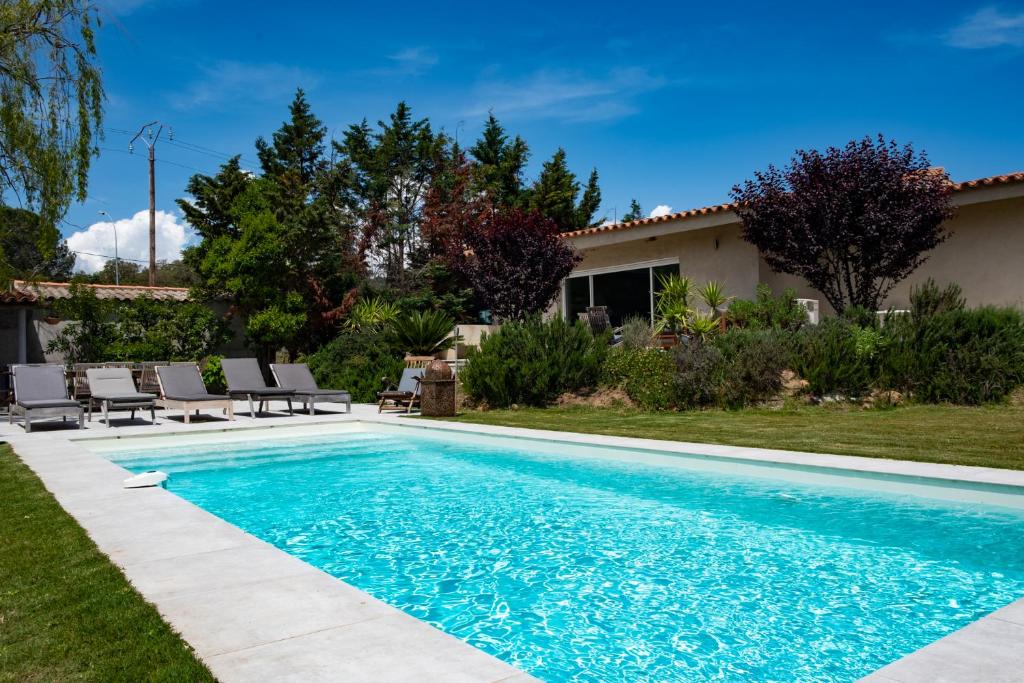 une piscine avec des chaises et une maison dans l'établissement Villa 13 couchages, à Porto-Vecchio