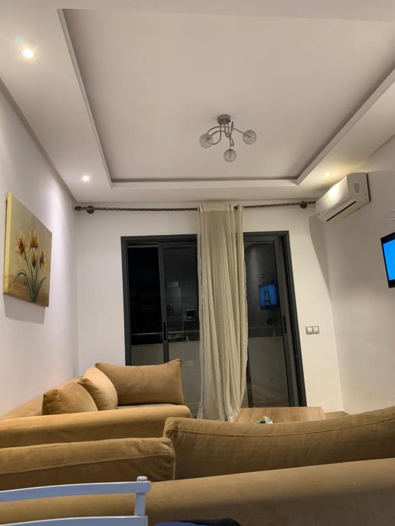 Una sala de estar con dos sofás y una ventana. en appartement de antoine, en Maarif