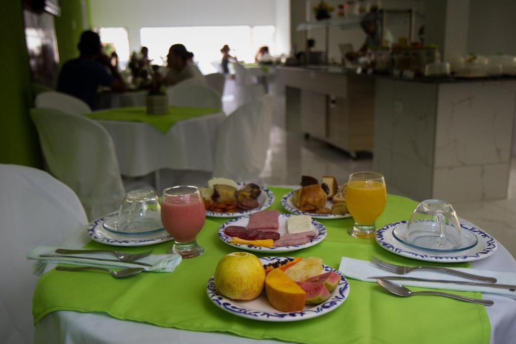 una mesa con platos de comida y vasos de zumo en Pousada Verdes Mares, en Maragogi