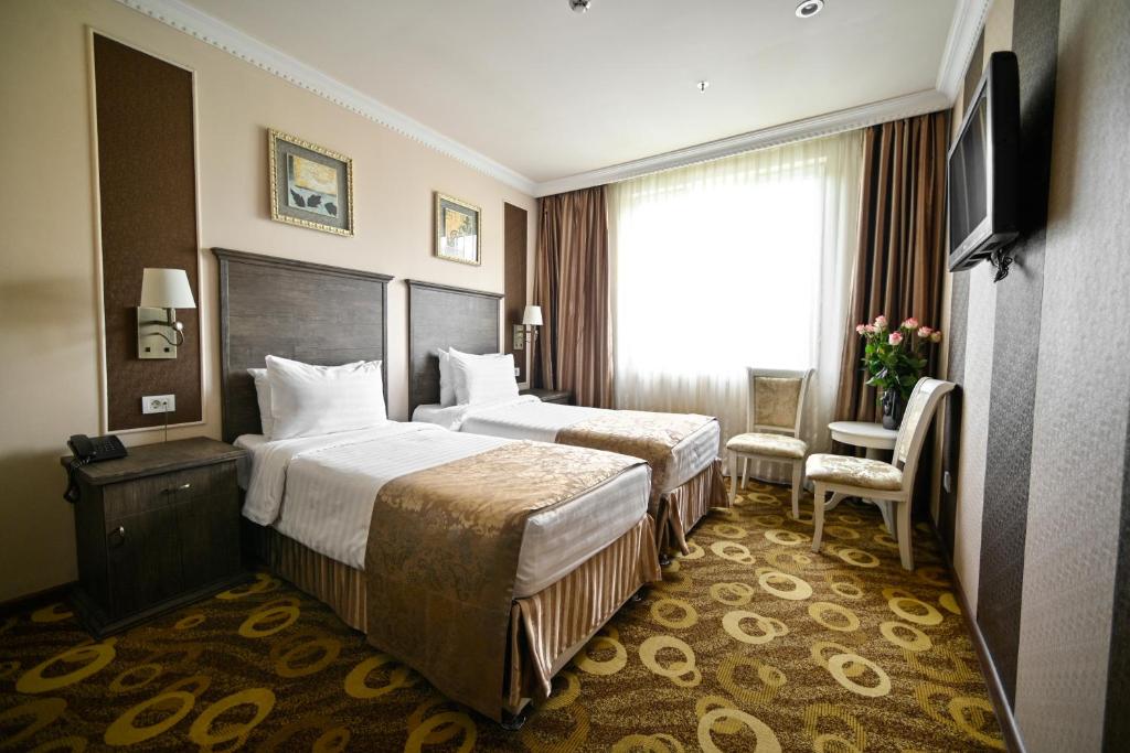 Postel nebo postele na pokoji v ubytování Imperial Palace Hotel Yerevan