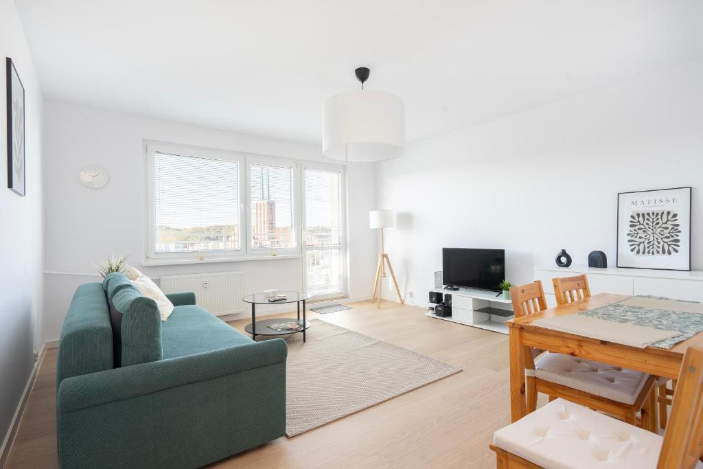 a living room with a blue couch and a table at 19 Apart in Gdynia