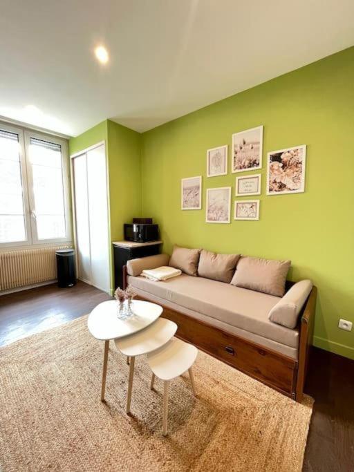 un salon avec un canapé et une table dans l'établissement Le refuge bohème, à Reims