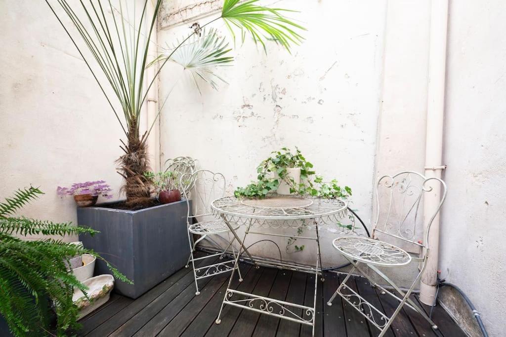une table et des chaises sur une terrasse avec des plantes dans l'établissement Spacious apartment in central Paris, à Paris
