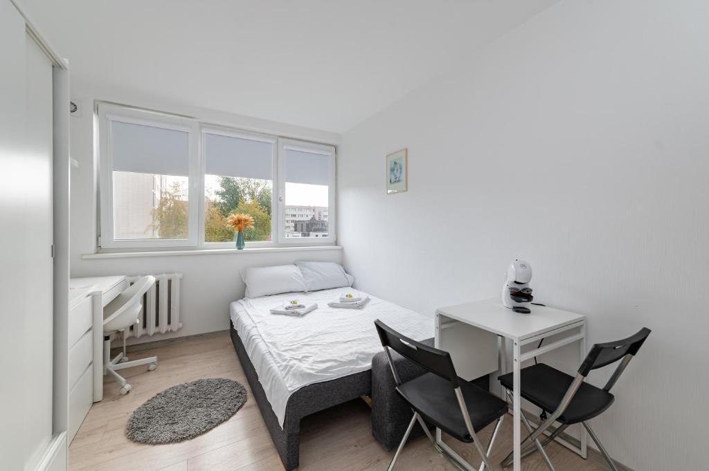 a bedroom with a bed and a desk and a window at Pramonės Apartment #8 by PoloApartments in Kaunas